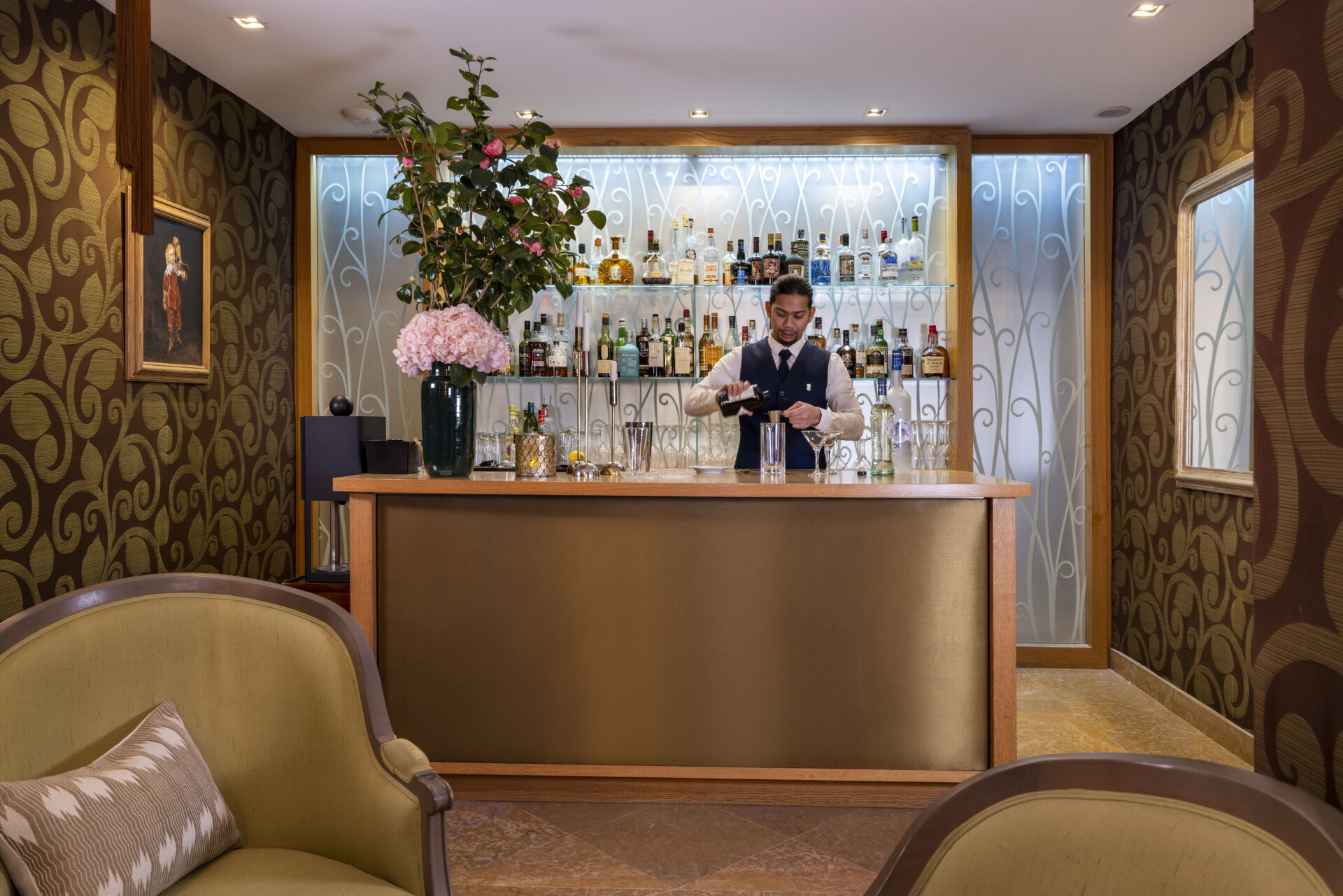 Barman préparant un cocktail derrière un bar élégant