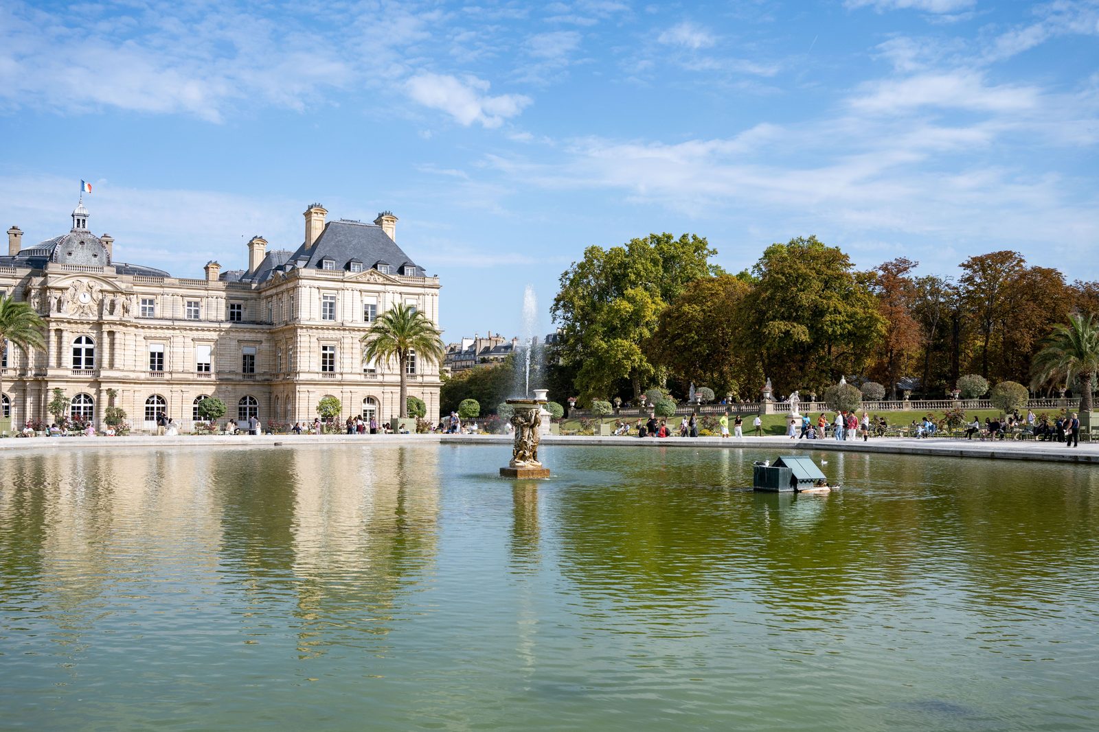 Palais du Luxembourg et grand bassin du jardin sous un ciel bleu