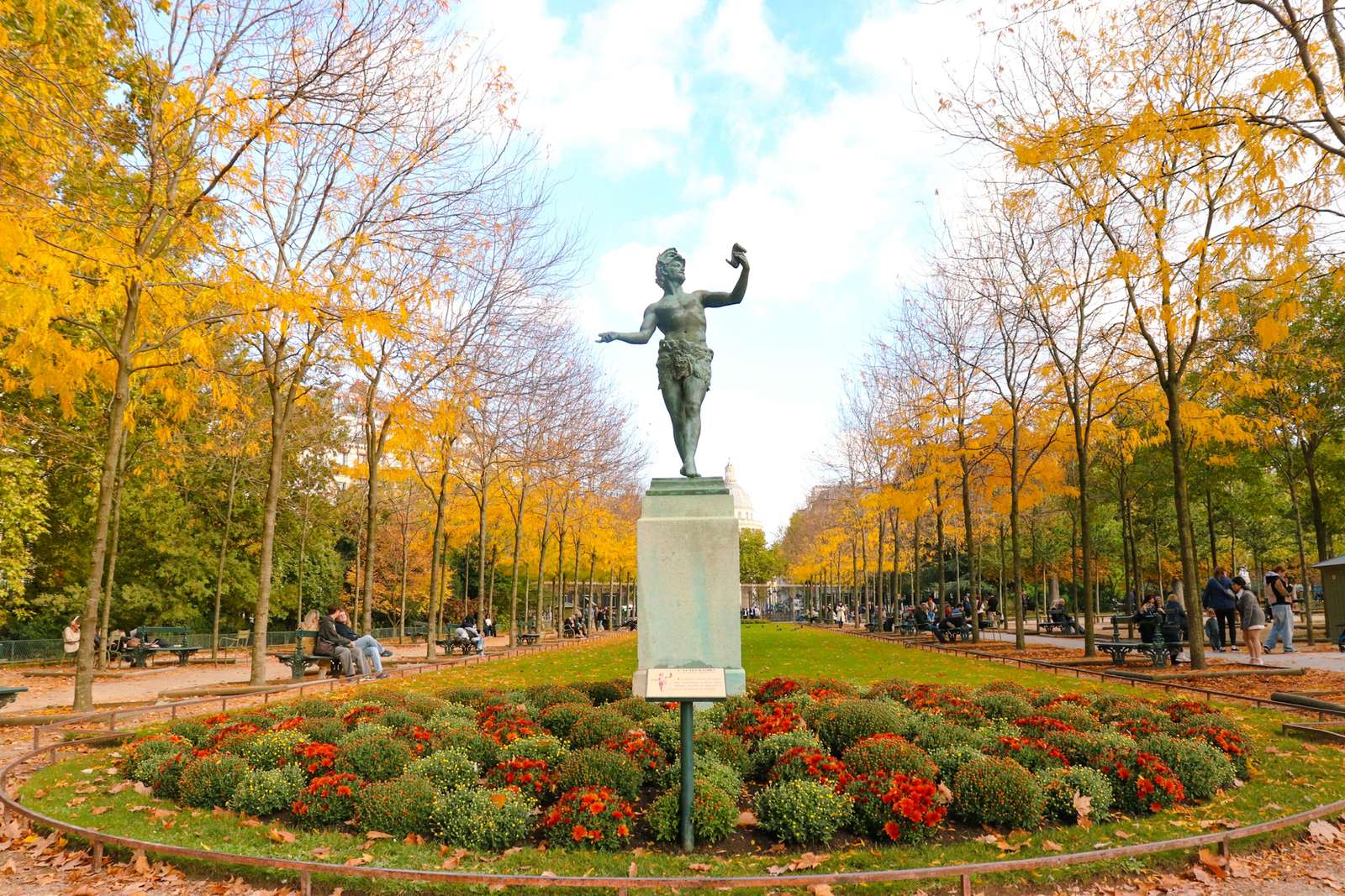Statue au jardin du Luxembourg entourée d’arbres aux feuillages dorés en automne