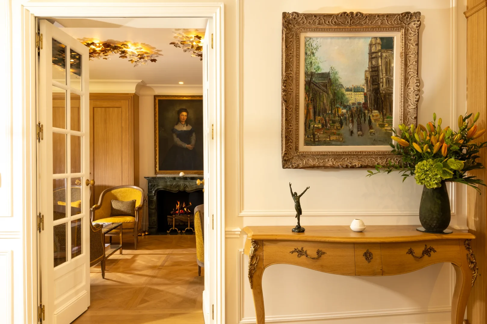Salon élégant avec cheminée, tableaux et bouquet de fleurs