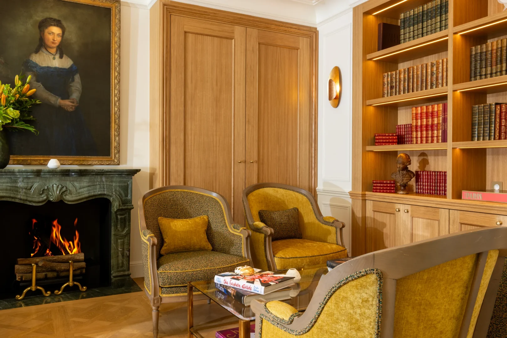 Salon élégant avec cheminée, bibliothèque et fauteuils jaunes
