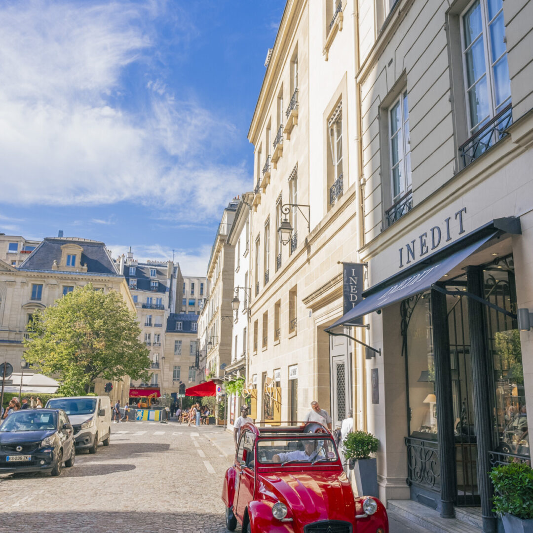 Voiture rouge vintage dans une rue parisienne